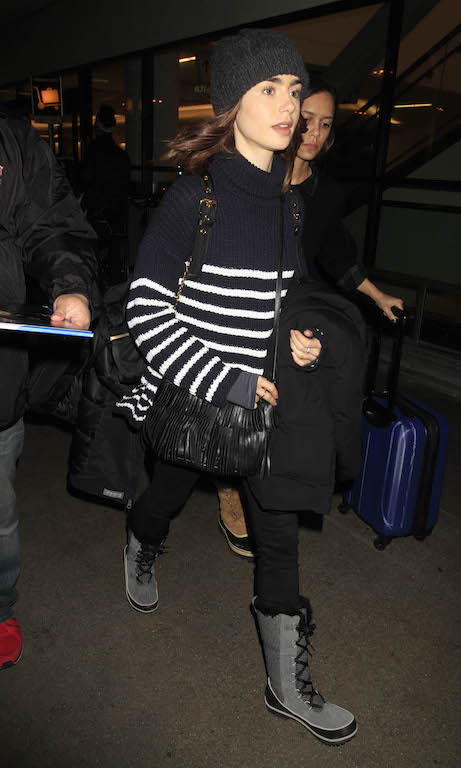 Lily Collins is seen making her way to a waiting limo as she makes an arrival into a rainy Los Angeles airport.