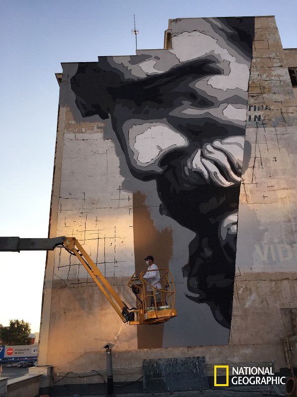 ATHENS - The street artist INO works on a massive mural of the ancient Greek thinker Democritus.  (photo credit: NGT/Chris Dye)