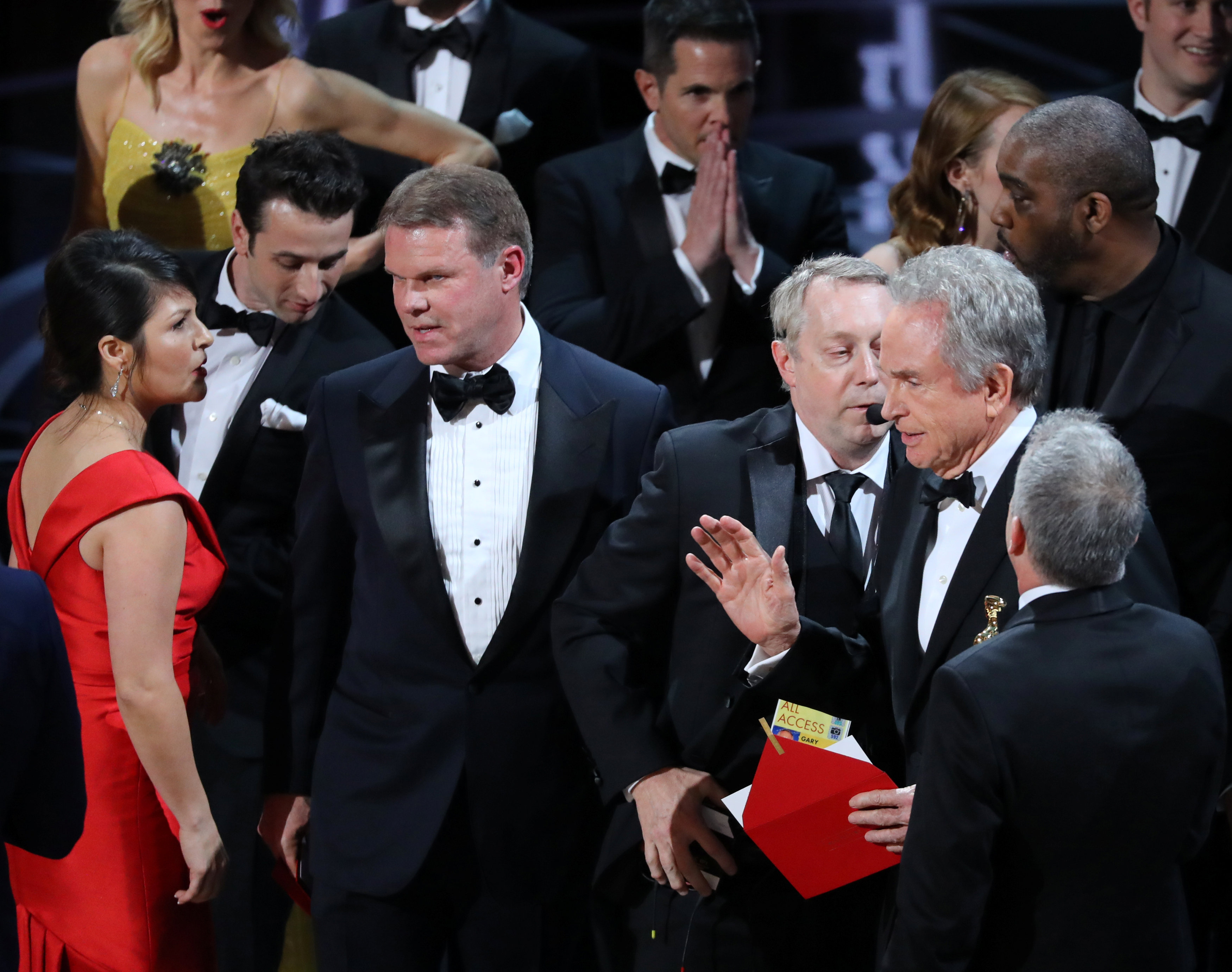 Martha Ruiz and Brian Cullinan of PricewaterhouseCoopers confer on stage during presentation of Best Picture at the 89th Academy Awards